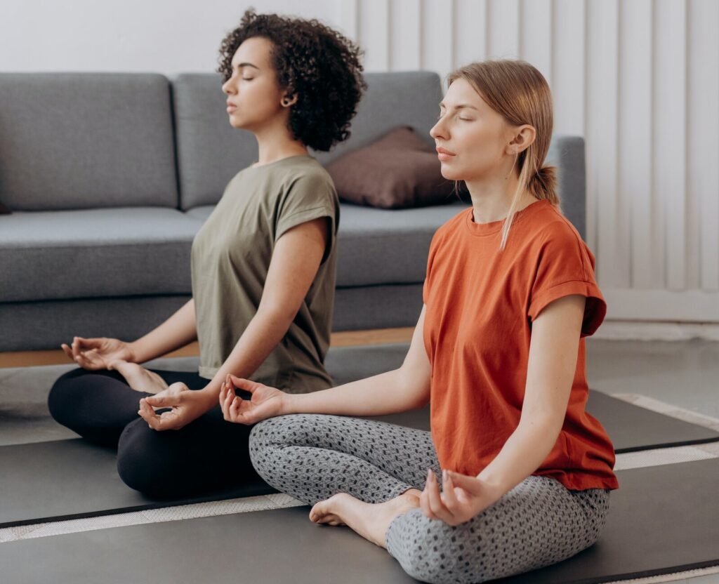 two women doing yoga pexels